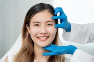 Woman smiles during an Asian eyelid surgery consultation with her surgeon