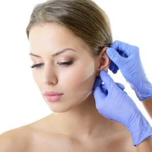 Beautiful young woman having her ears examined by her plastic surgeon in preparation for an otoplasty.